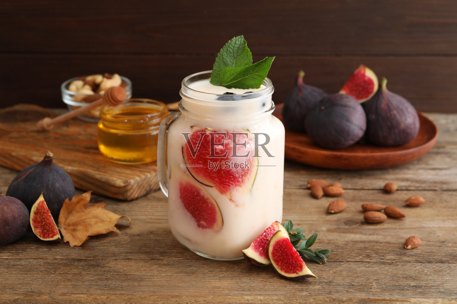 木桌上，盛在玻璃瓶里的美味无花果冰沙照片摄影图片