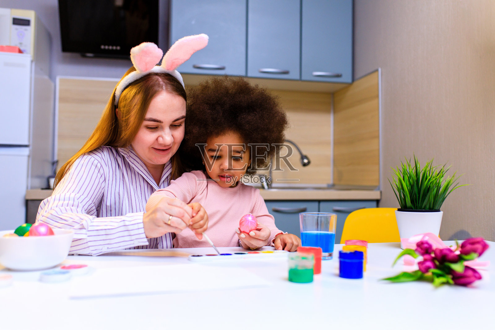 多民族家庭在厨房粉刷彩蛋，准备复活节活动照片摄影图片