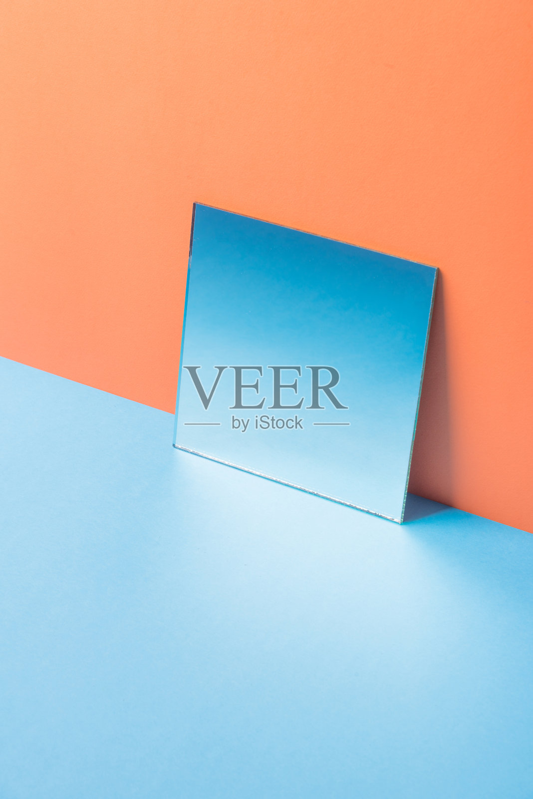 镜子在蓝色的桌子上孤立的橙色背景照片摄影图片