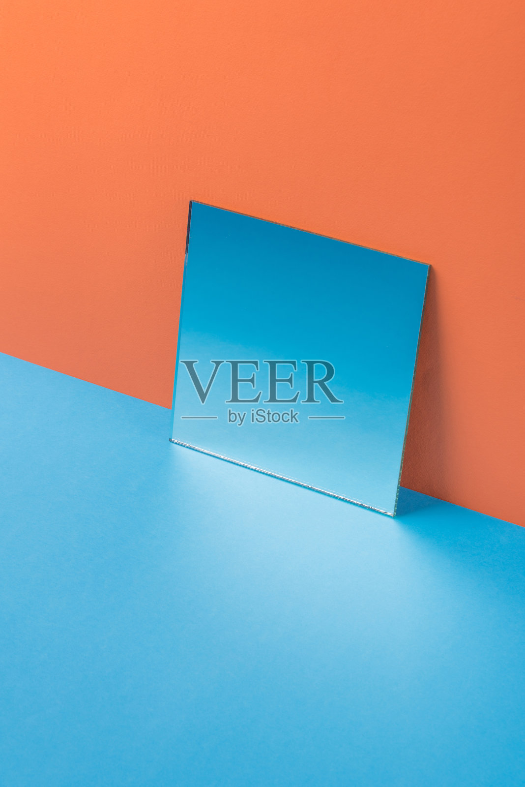 镜子在蓝色的桌子上孤立的橙色背景照片摄影图片