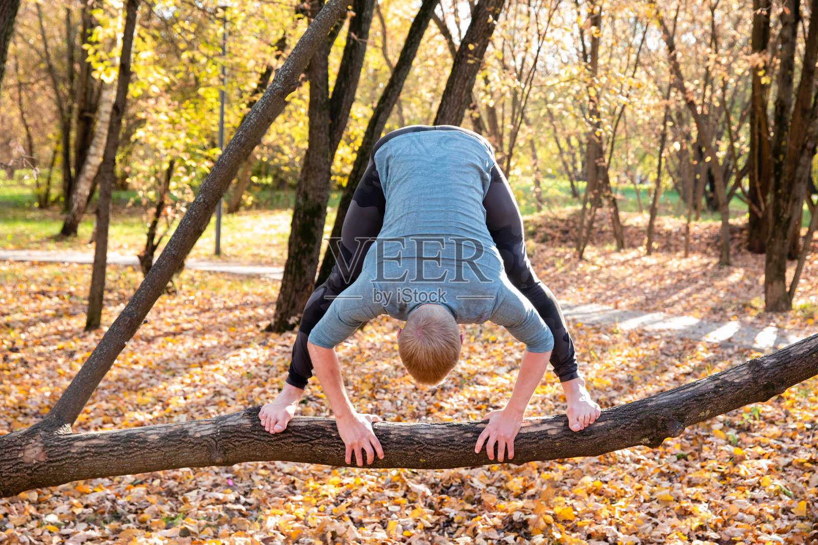 在秋天的公园里练习瑜伽的运动男子照片摄影图片