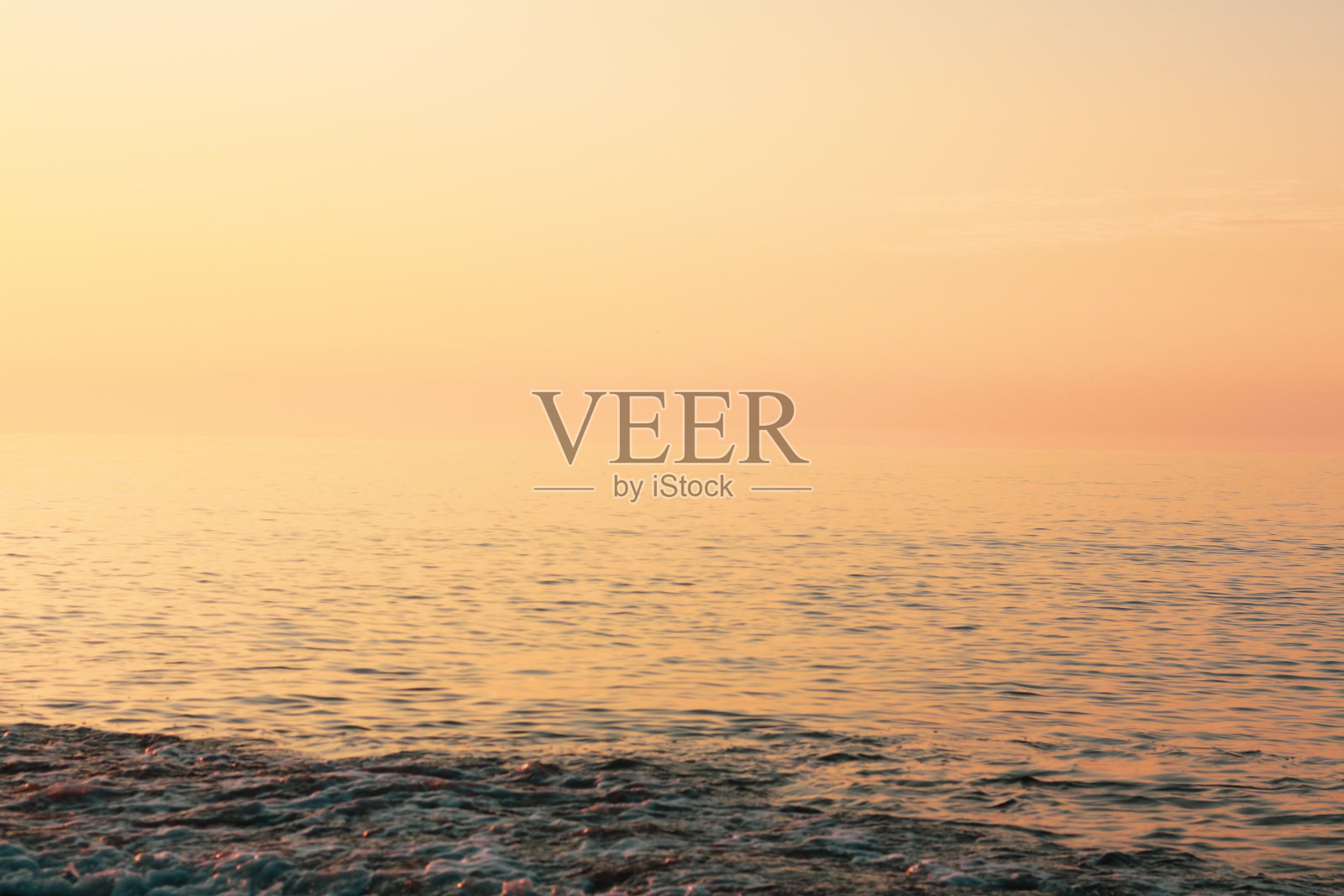 平静的海洋或海水在美丽的温暖的日落颜色照片摄影图片