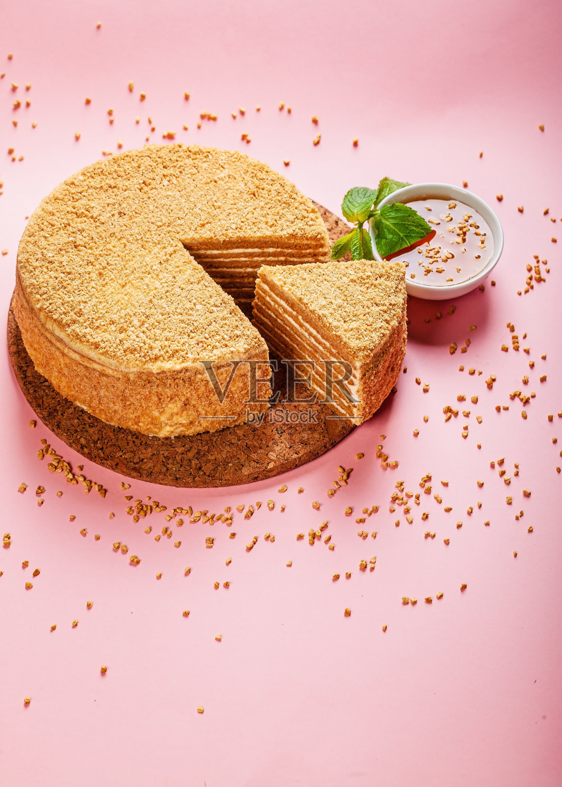 粉红色背景的酸奶油自制蜂蜜蛋糕。自制美味甜美的糕点。垂直拍摄。本空间照片摄影图片