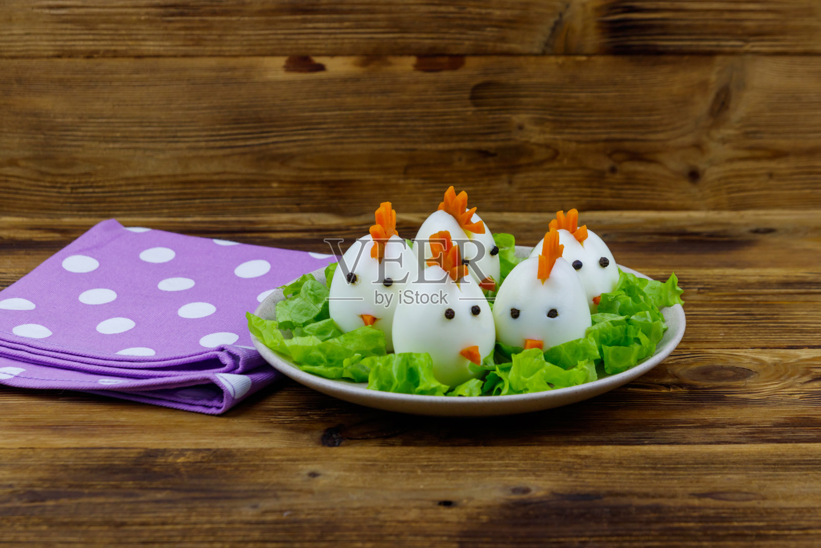 有趣的复活节早餐，把煮鸡蛋做成小鸡放在木桌上照片摄影图片