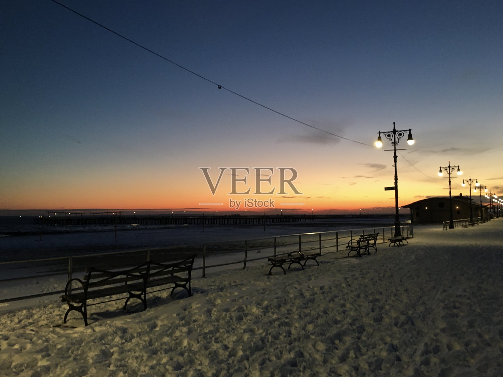 一月雪中的日落在科尼岛在布鲁克林，纽约，纽约。照片摄影图片