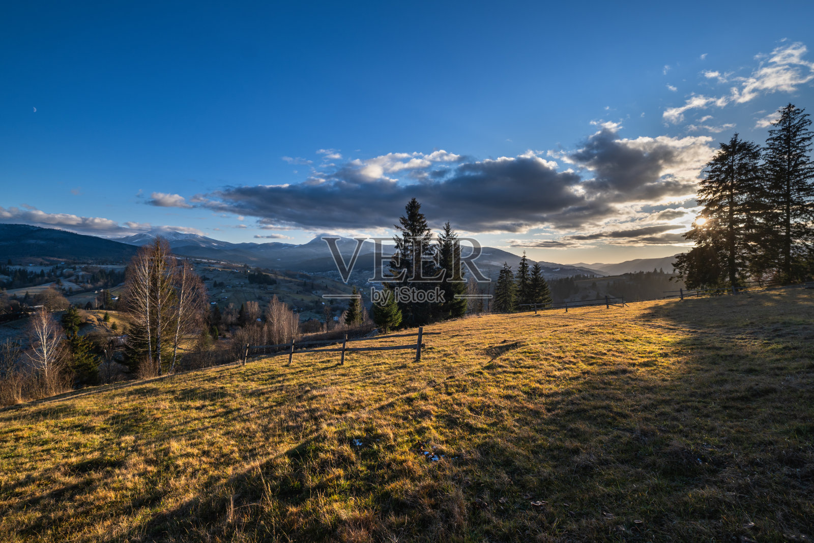 深秋的山，日落前的景象，白雪覆盖的山顶在远处。风景如画的旅游，季节，自然和乡村美的概念场景。喀尔巴阡山,乌克兰。照片摄影图片
