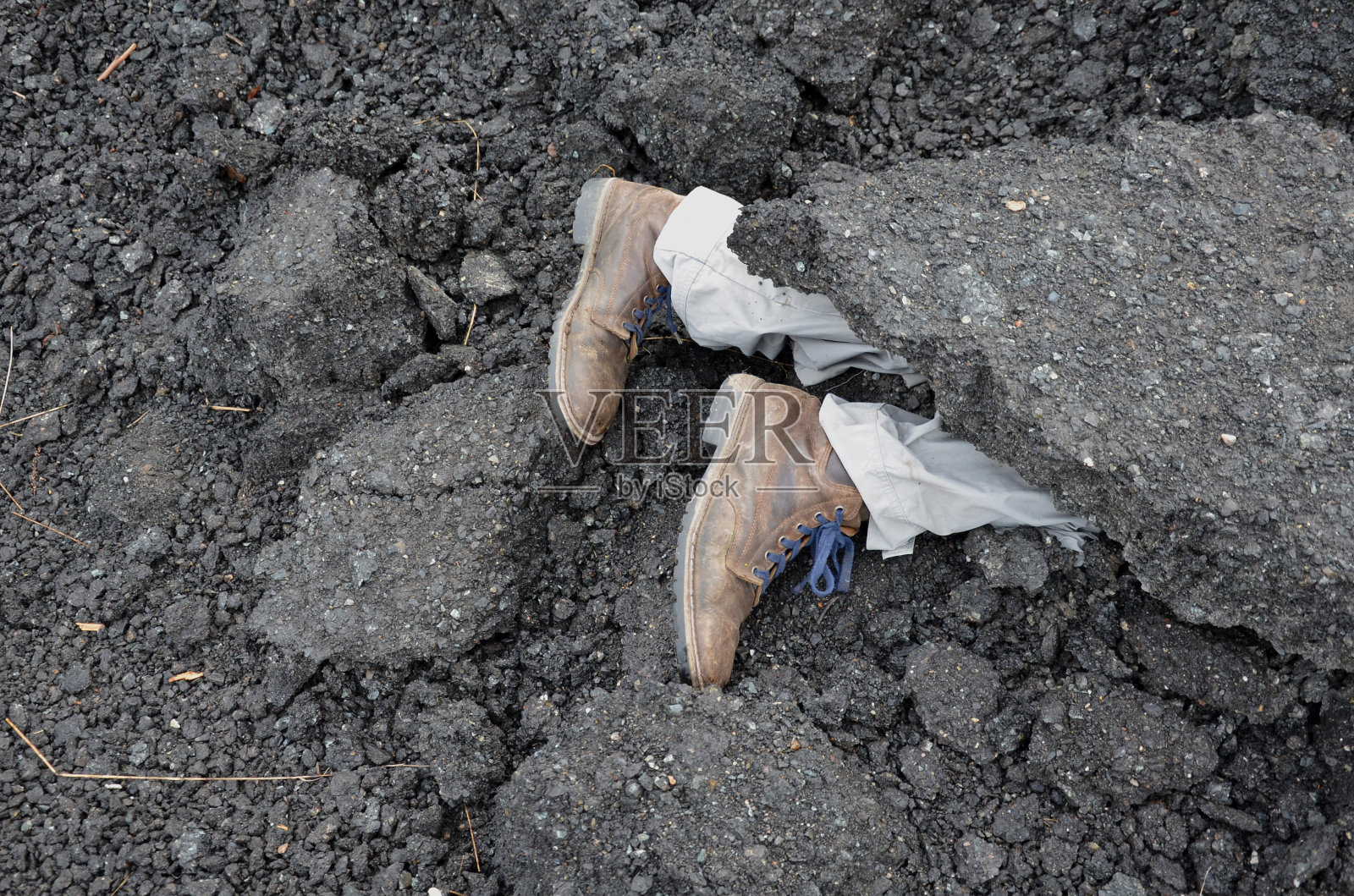 大块的柏油路部分覆盖了废墟下一个男人的身影。在建筑工地进行跳伞回填。在野外训练期间，在救援人员和经过特殊训练的狗的帮助下进行救援照片摄影图片