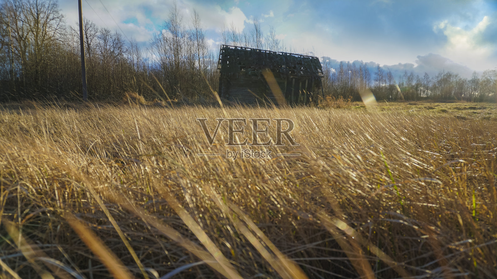 废弃的木屋，干草和阴云密布的天空照片摄影图片