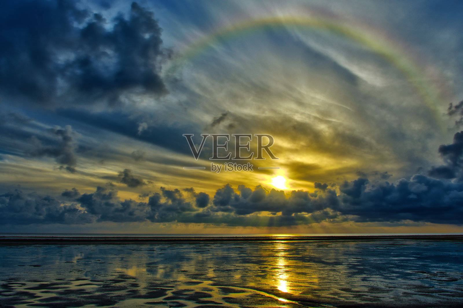 低潮时泥滩上的虹，羽毛般的云，日出时的积云照片摄影图片