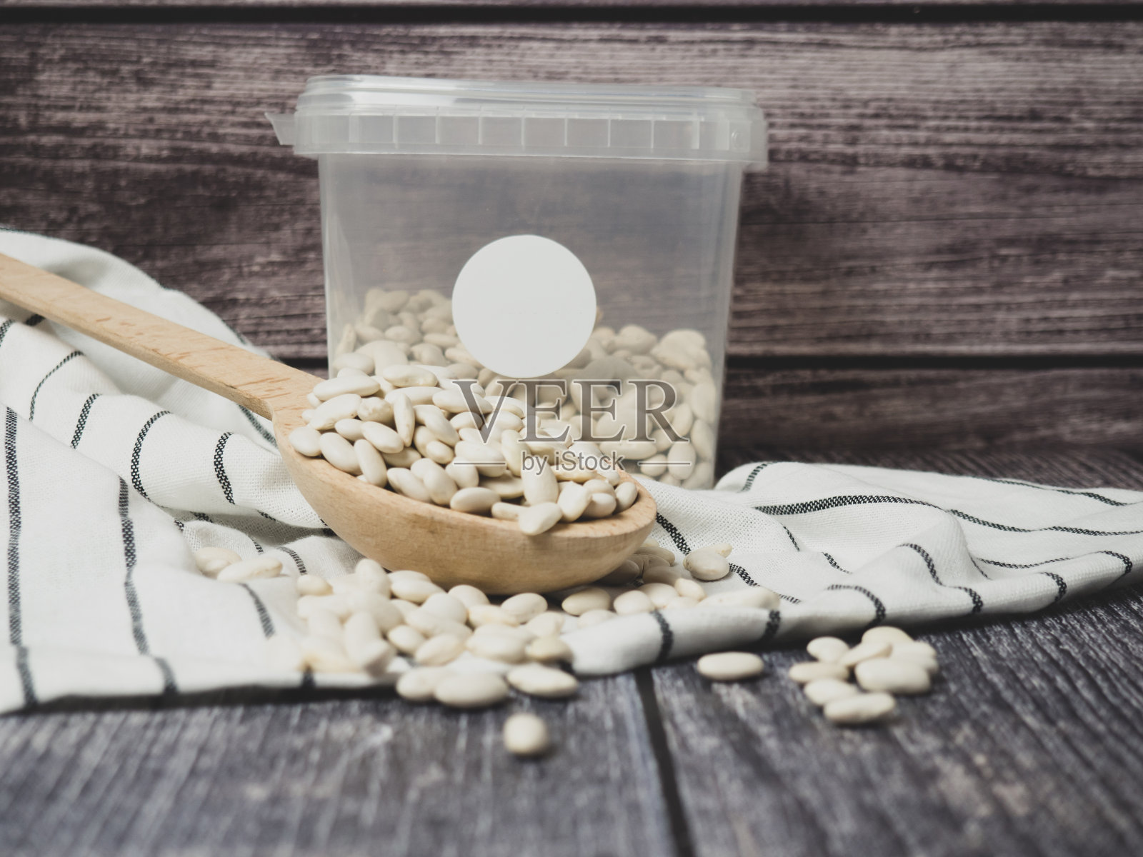 桌上散落着木杯和木勺里的白豆照片摄影图片