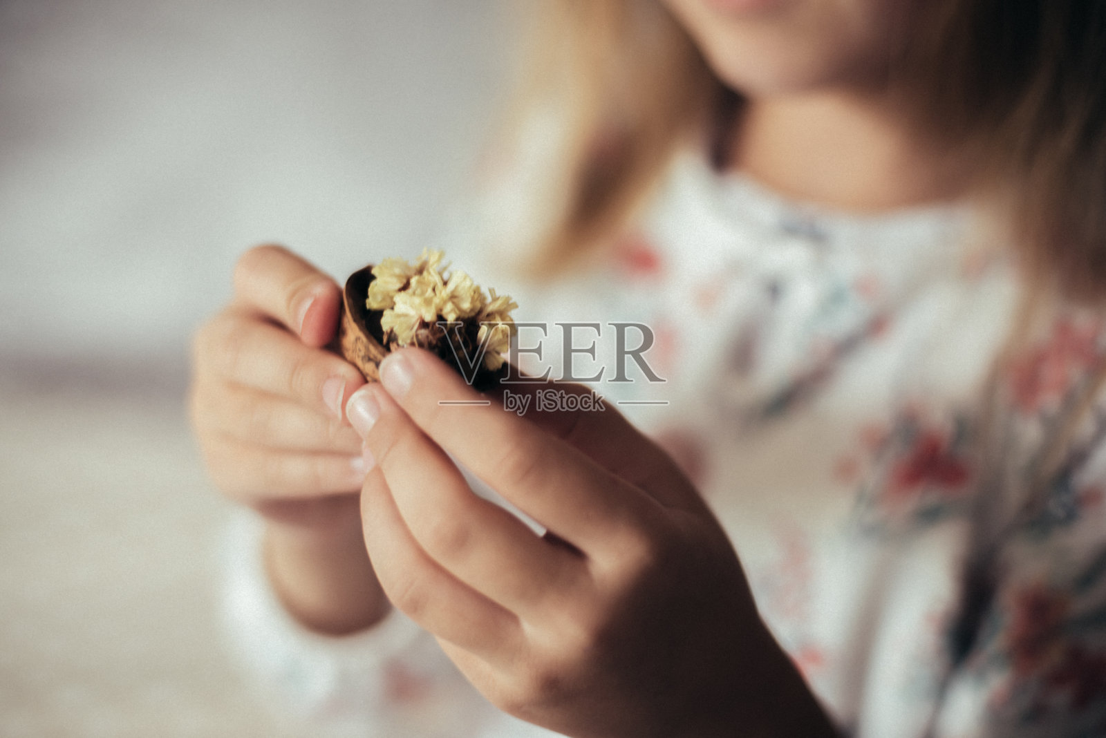 那孩子拿着花。照片摄影图片