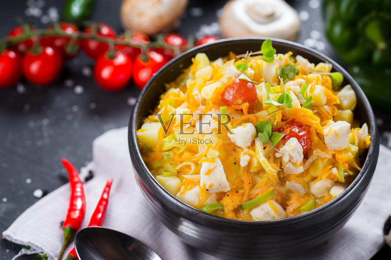 在一个盘子上冷汤蔬菜和鸡肉，圣女果，刀具在一个黑色孤立的背景，顶部照片摄影图片