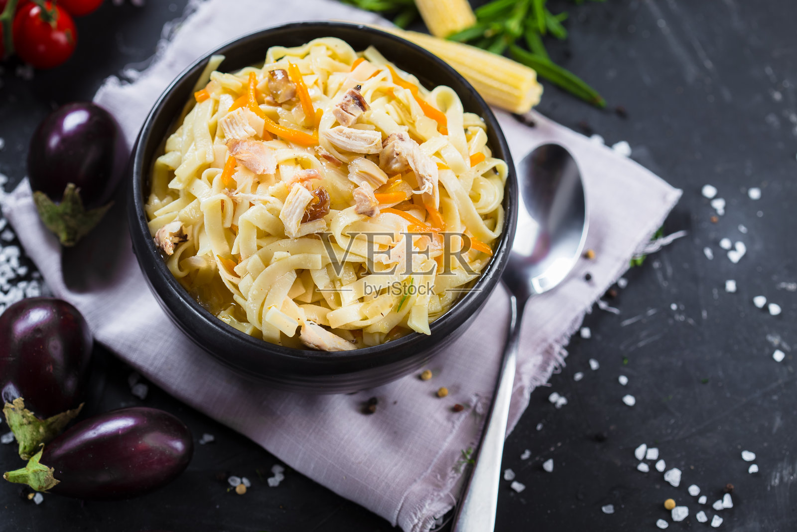 在浅盘意大利面，肉和蔬菜，圣女果，刀具在一个黑色孤立的背景，顶部照片摄影图片