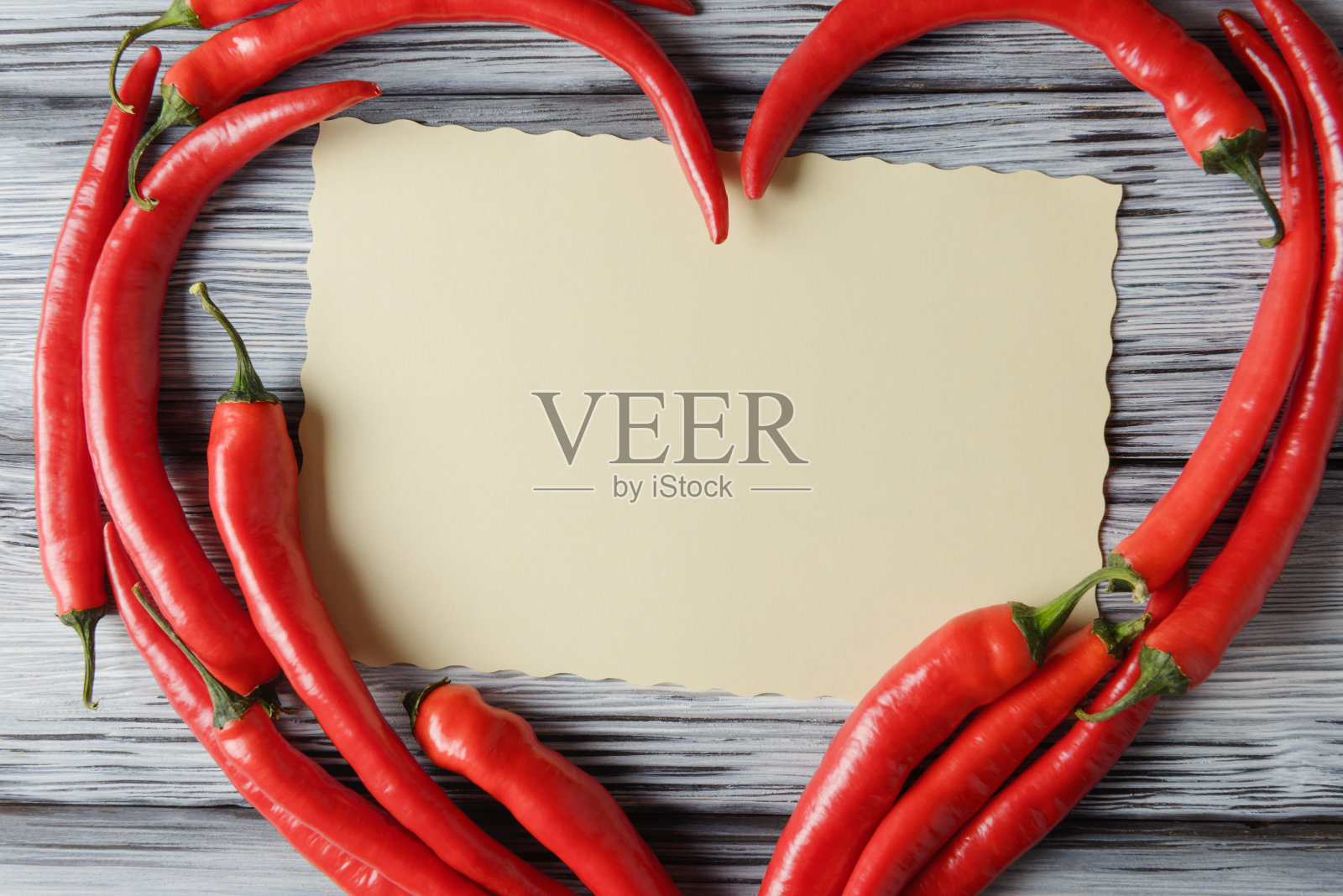 红辣椒位于心脏形状和空白卡片木制背景。Valentinea节的概念照片摄影图片
