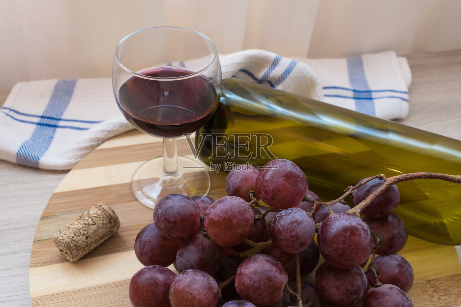 一杯红酒，一串葡萄和一瓶照片摄影图片