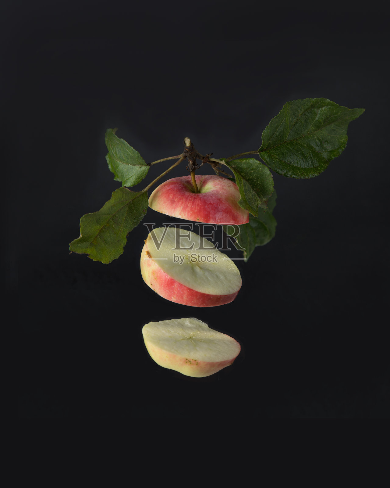 切好的苹果在黑色的背景上飞舞。照片摄影图片