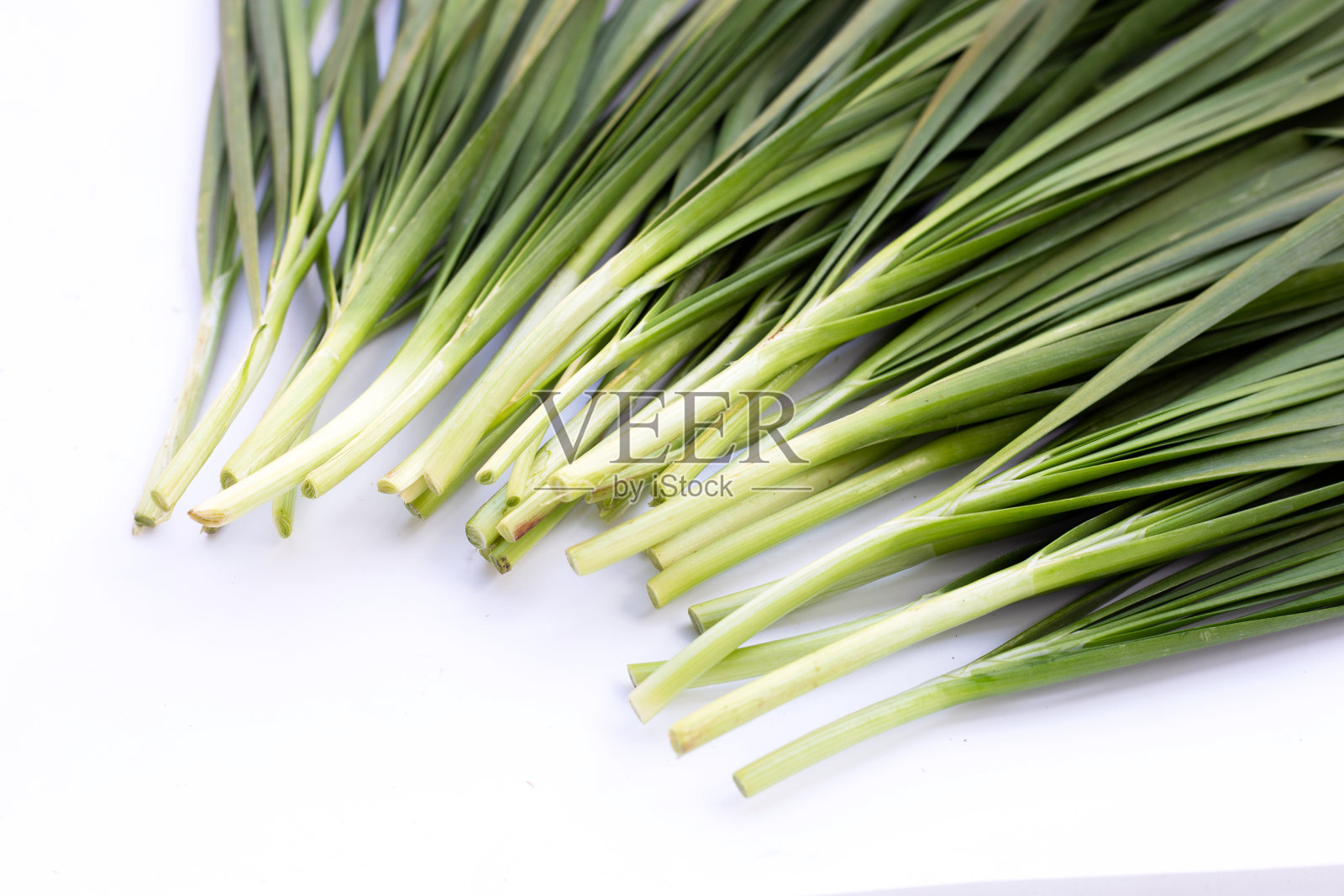鲜韭菜叶白色背景。照片摄影图片