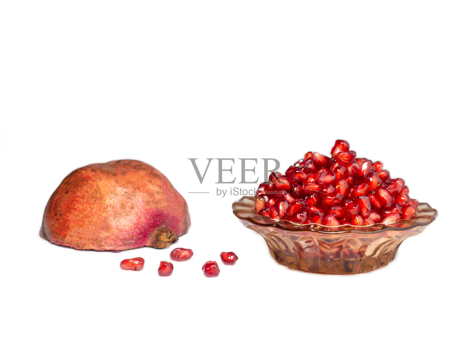 在白色的底色上放上石榴籽和一半石榴照片摄影图片