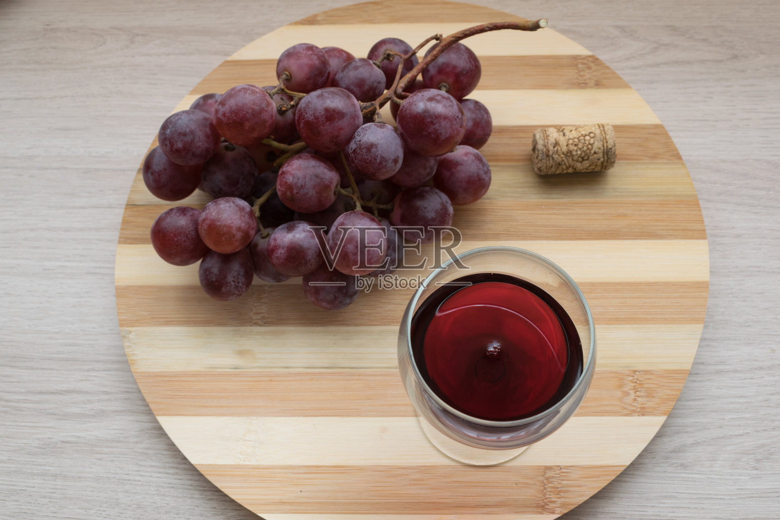 一杯红酒，一串葡萄和一瓶木制背景的葡萄酒照片摄影图片