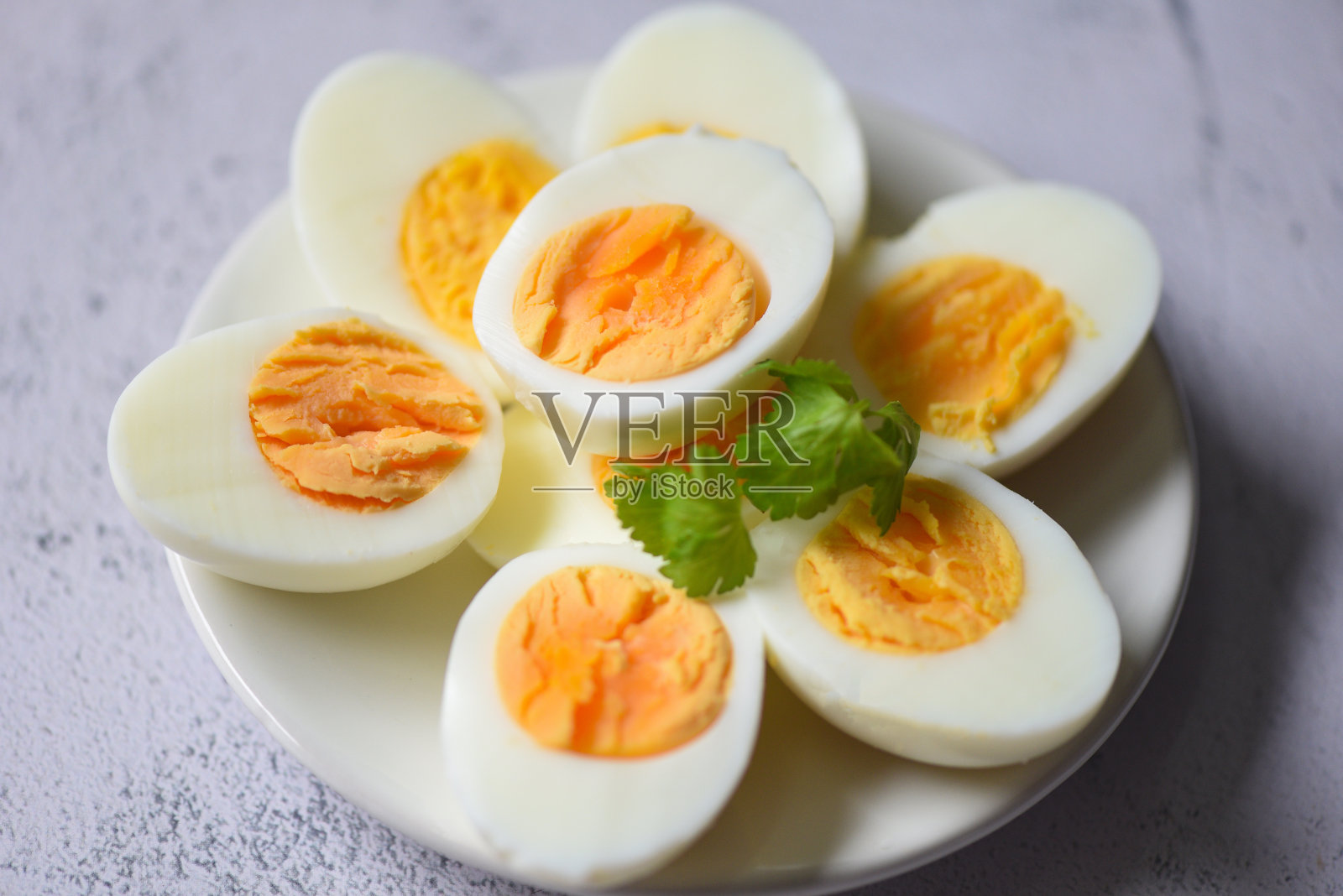 鸡蛋菜单食物煮鸡蛋在一个白色的盘子装饰绿叶香菜，蛋黄切成一半，烹饪健康的吃鸡蛋早餐照片摄影图片