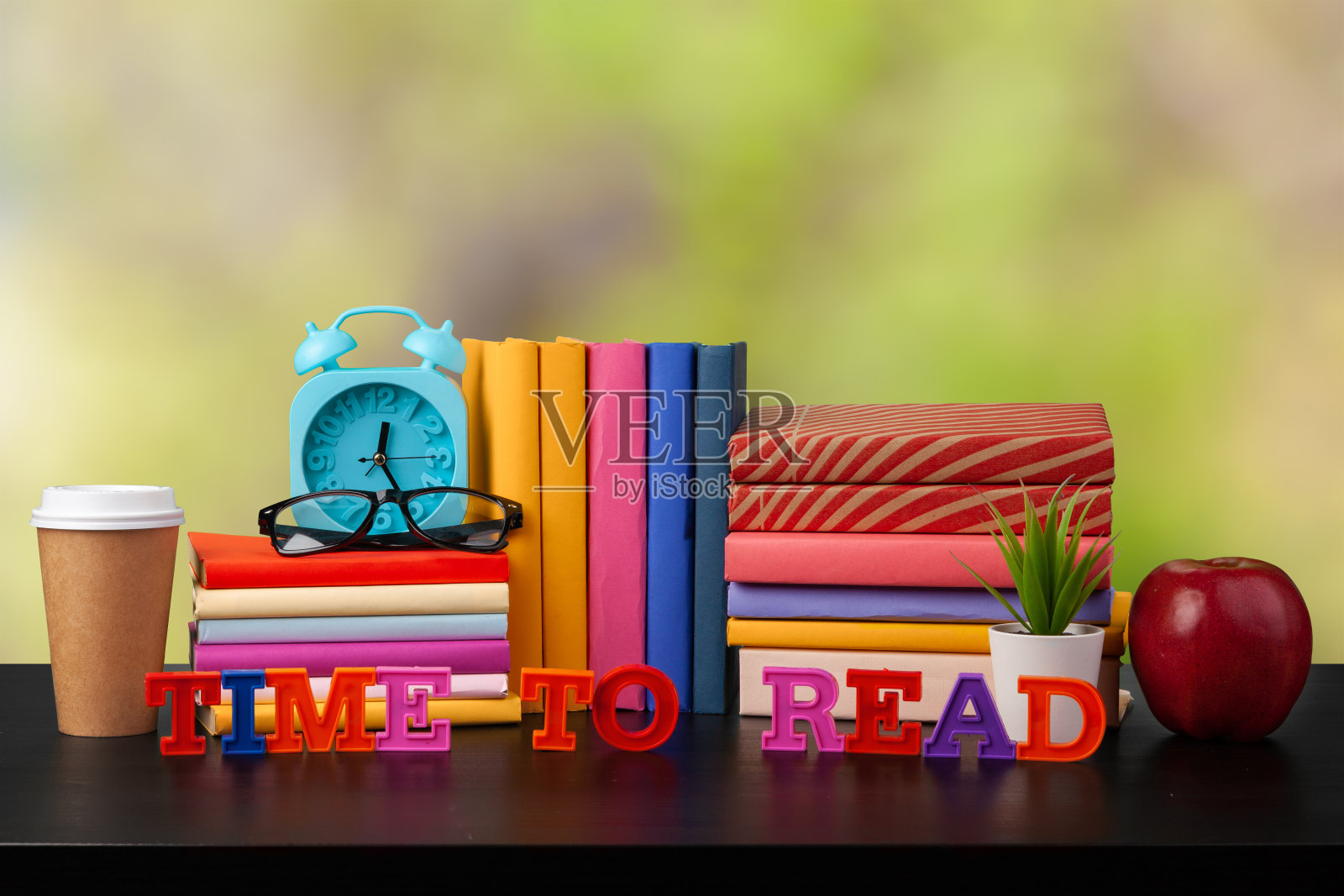 木桌上一堆书，背景模糊照片摄影图片