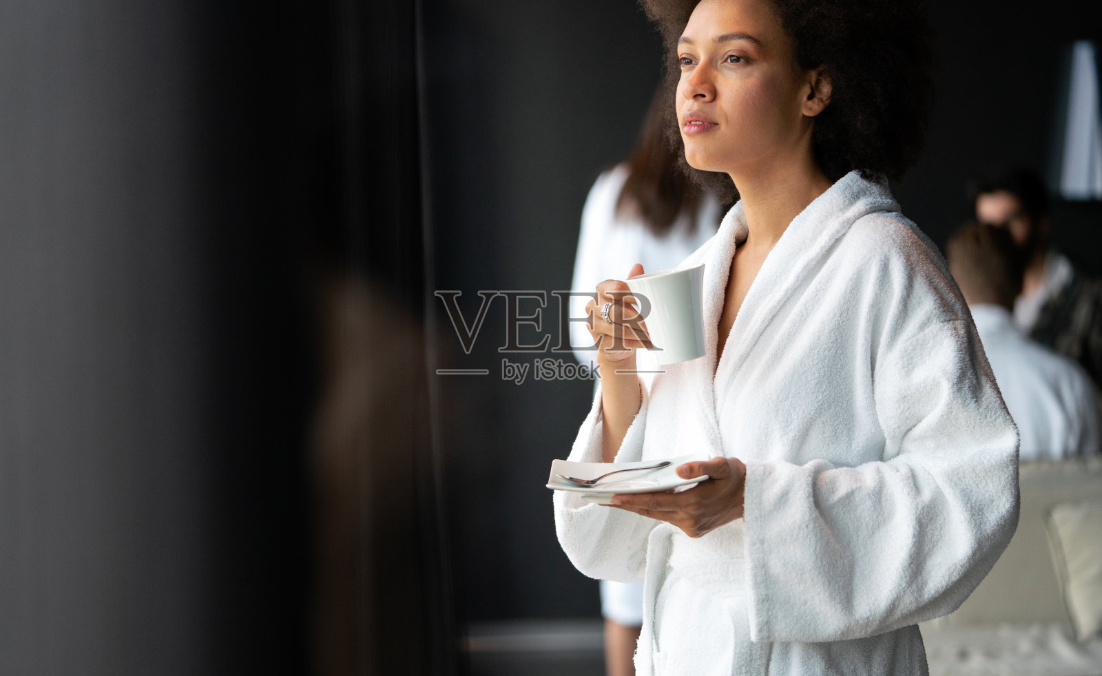 一个年轻健康的漂亮黑人妇女的肖像，放松地穿着长袍，喝咖啡照片摄影图片