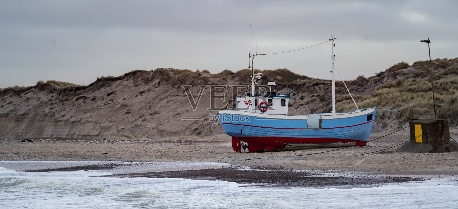 在一个暴风雨的日子里，丹麦北部norre vorupor海滩上的传统渔船照片摄影图片