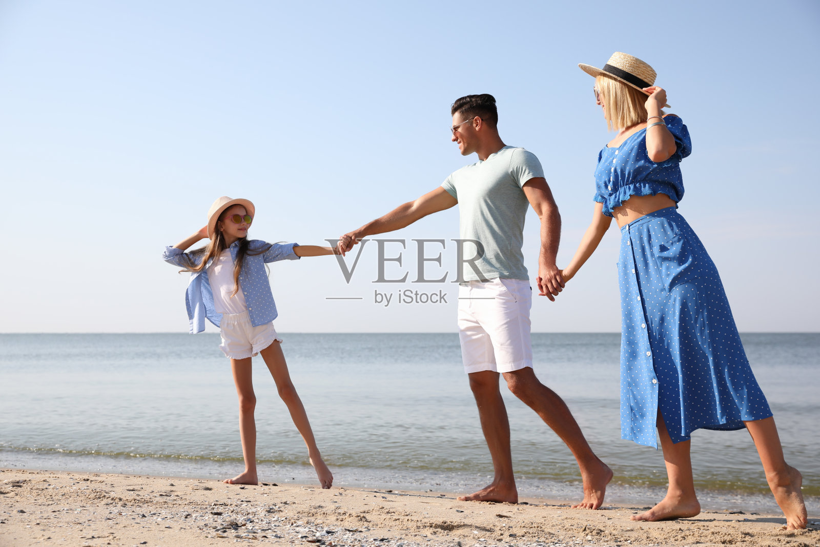 幸福的家庭在阳光明媚的夏日海滩照片摄影图片