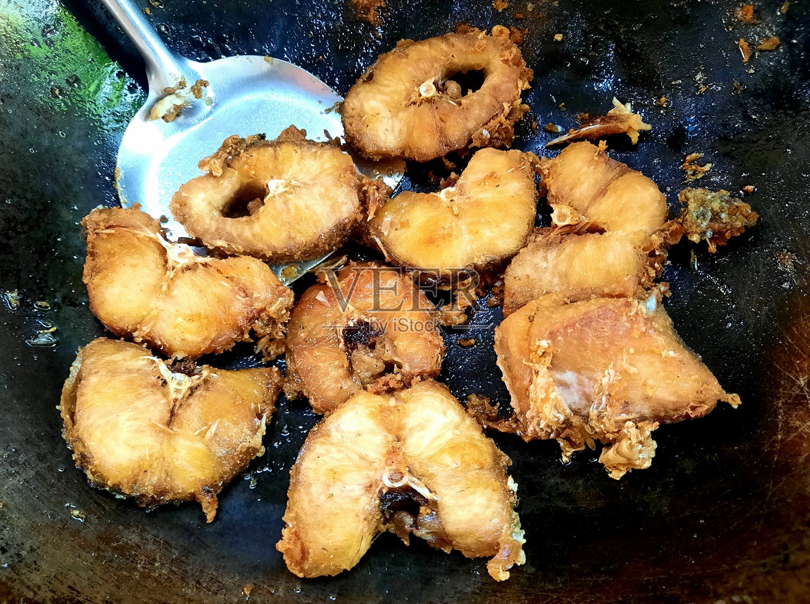 油炸黑鱼片在烹饪锅-食物准备。照片摄影图片