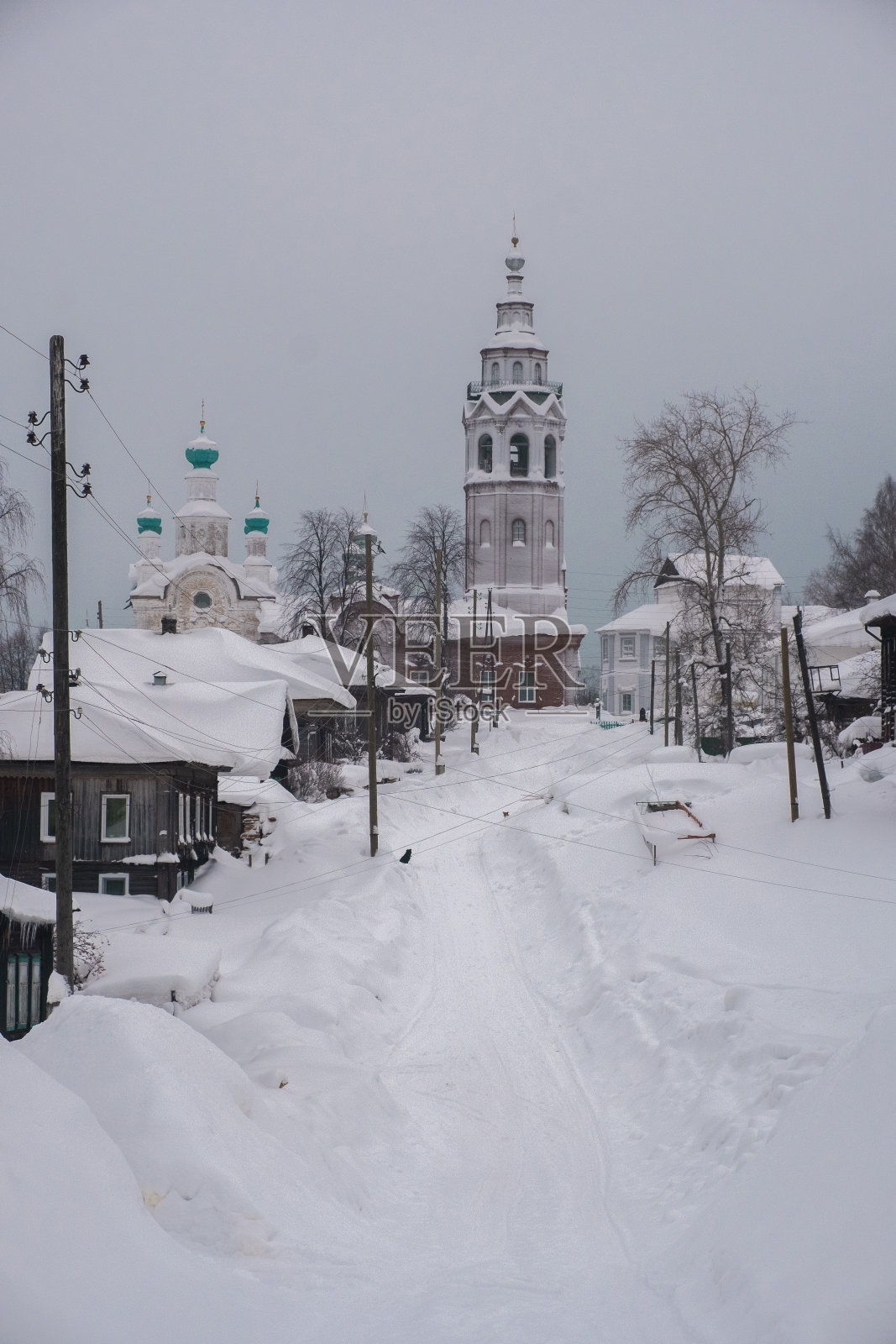 雪覆盖在Cherdyn古镇的街道上，冬天有木屋和东正教教堂。烫地区俄罗斯。照片摄影图片