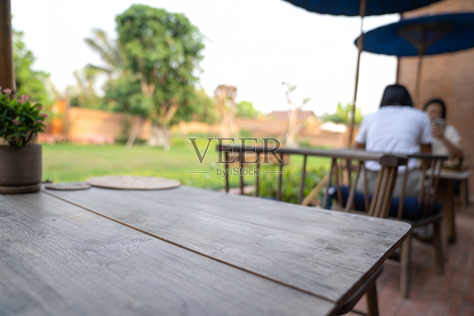 泰国北方传统现代组合木桌和椅子设置在花园的柳条板模糊背景照片摄影图片