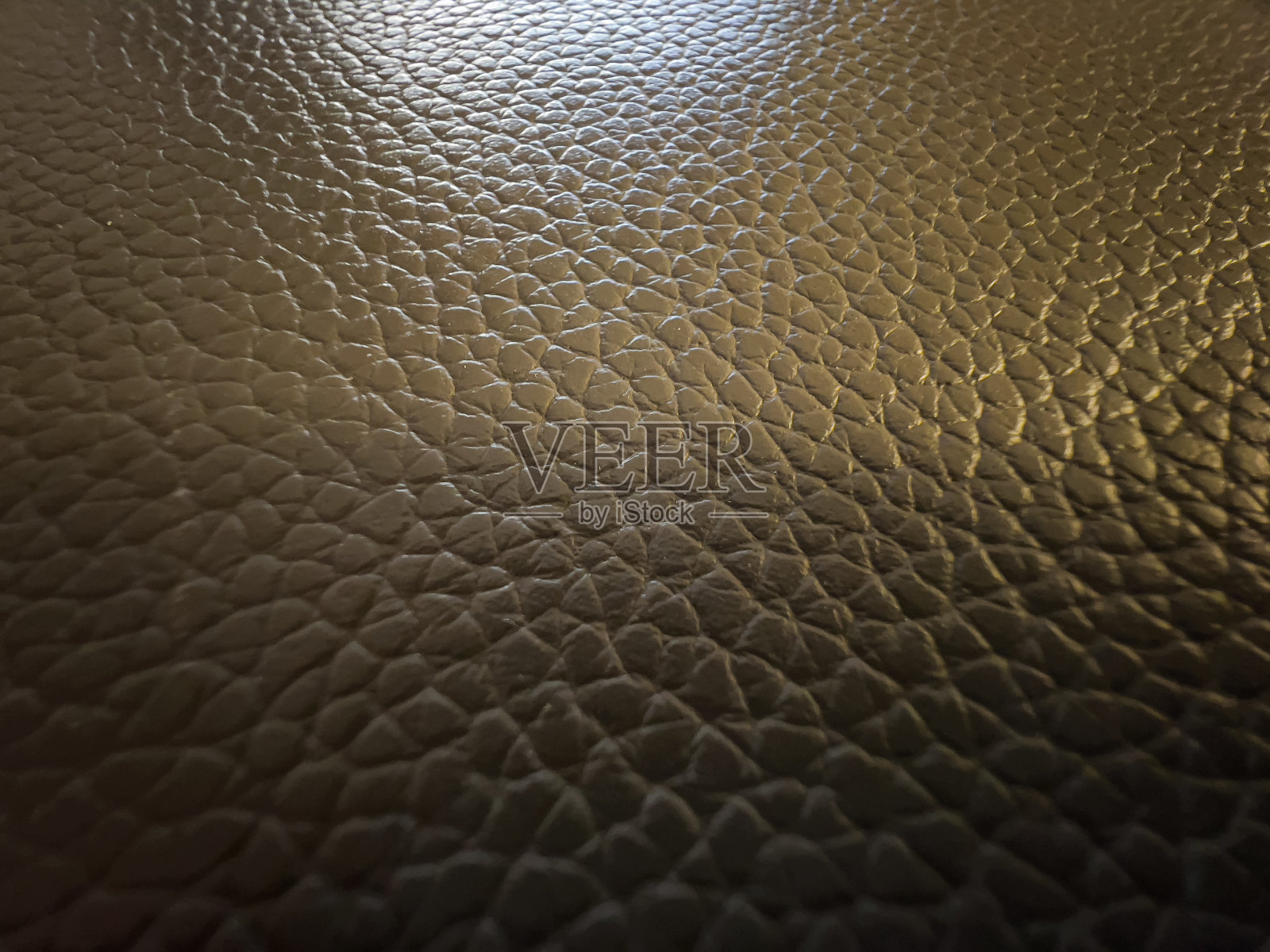 一种精细的、有图案的深褐色皮革。照片摄影图片