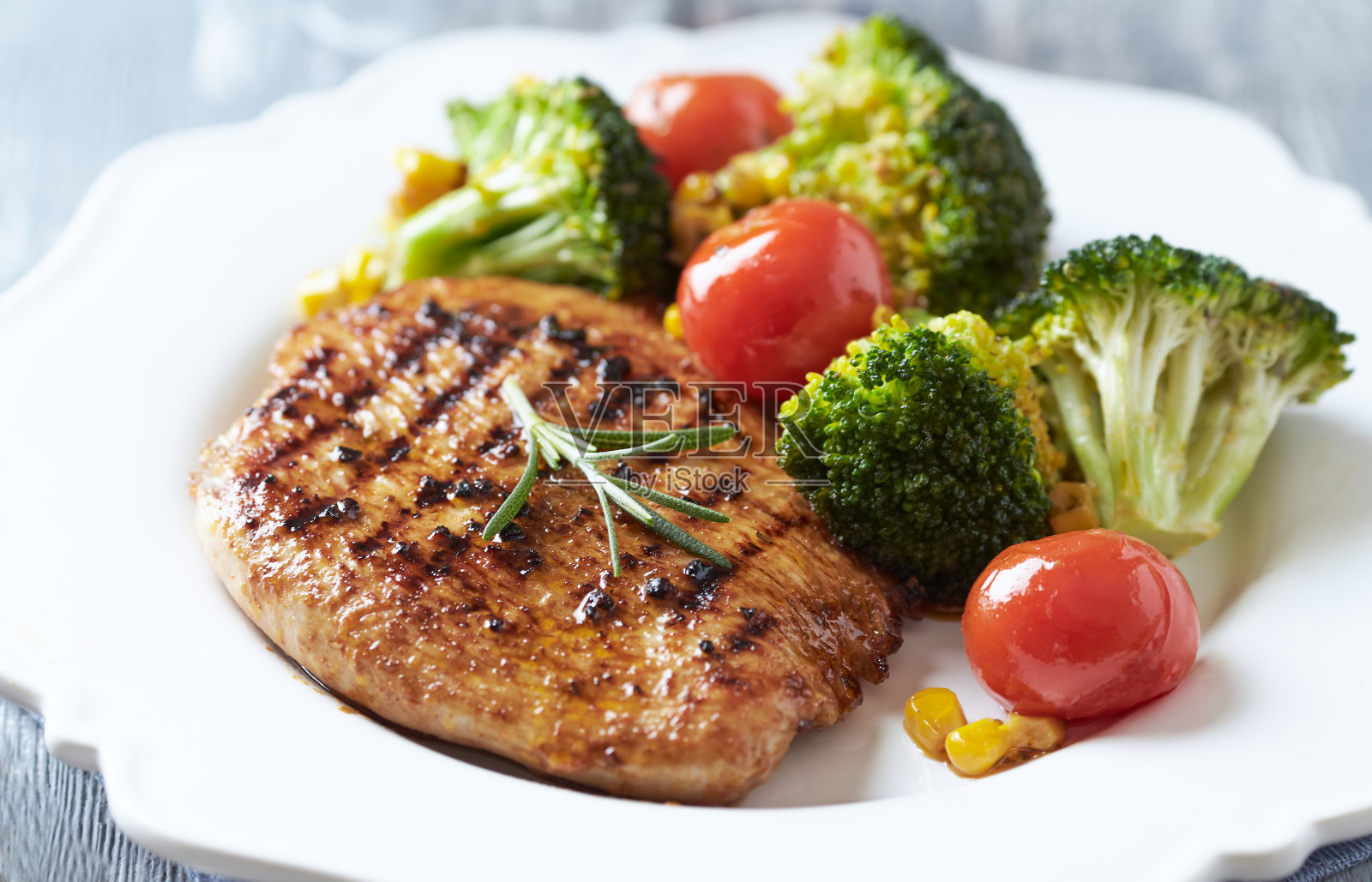 烤火鸡胸肉配烤炉烤西兰花，圣女果和甜玉米。关闭了。照片摄影图片