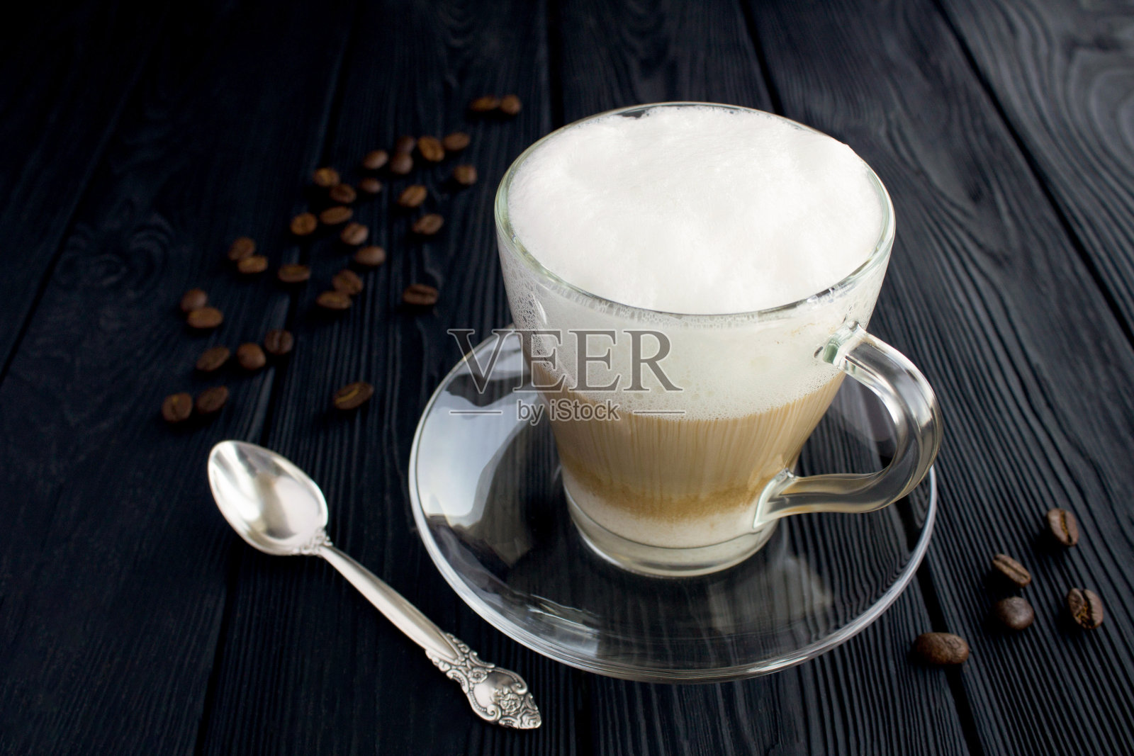 拿铁咖啡在黑色木质背景的玻璃杯中。特写镜头。照片摄影图片