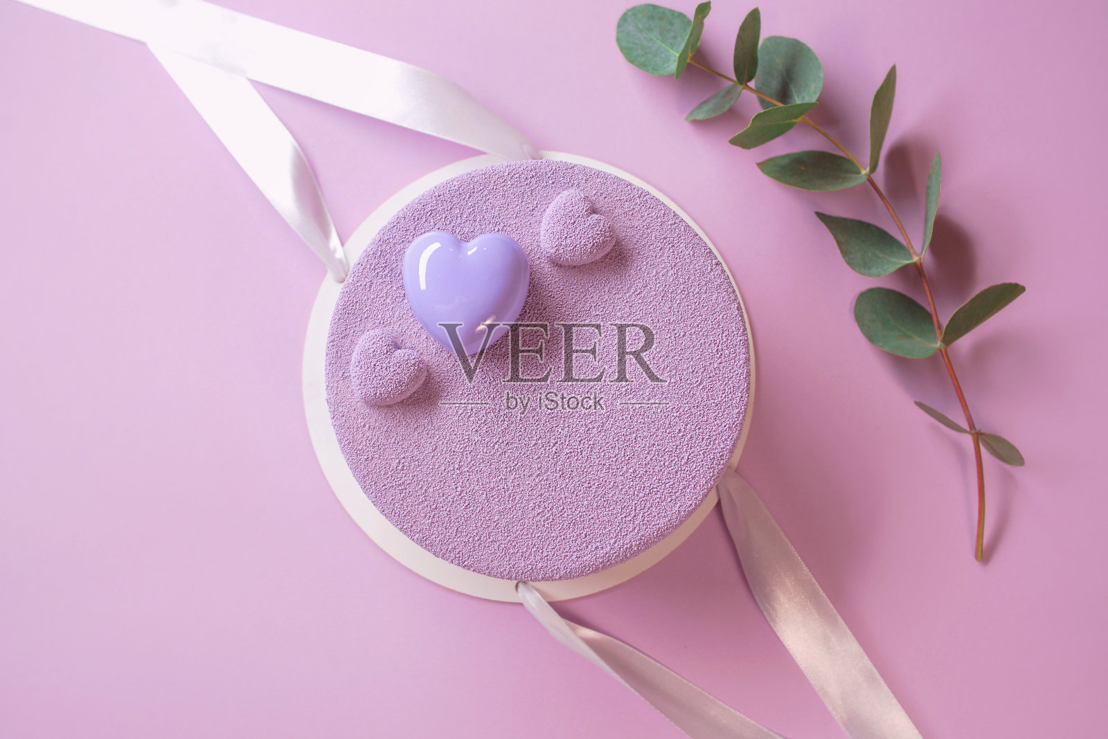 美丽时尚的现代紫罗兰，紫色的自制蛋糕在紫色的背景与桉树树枝照片摄影图片