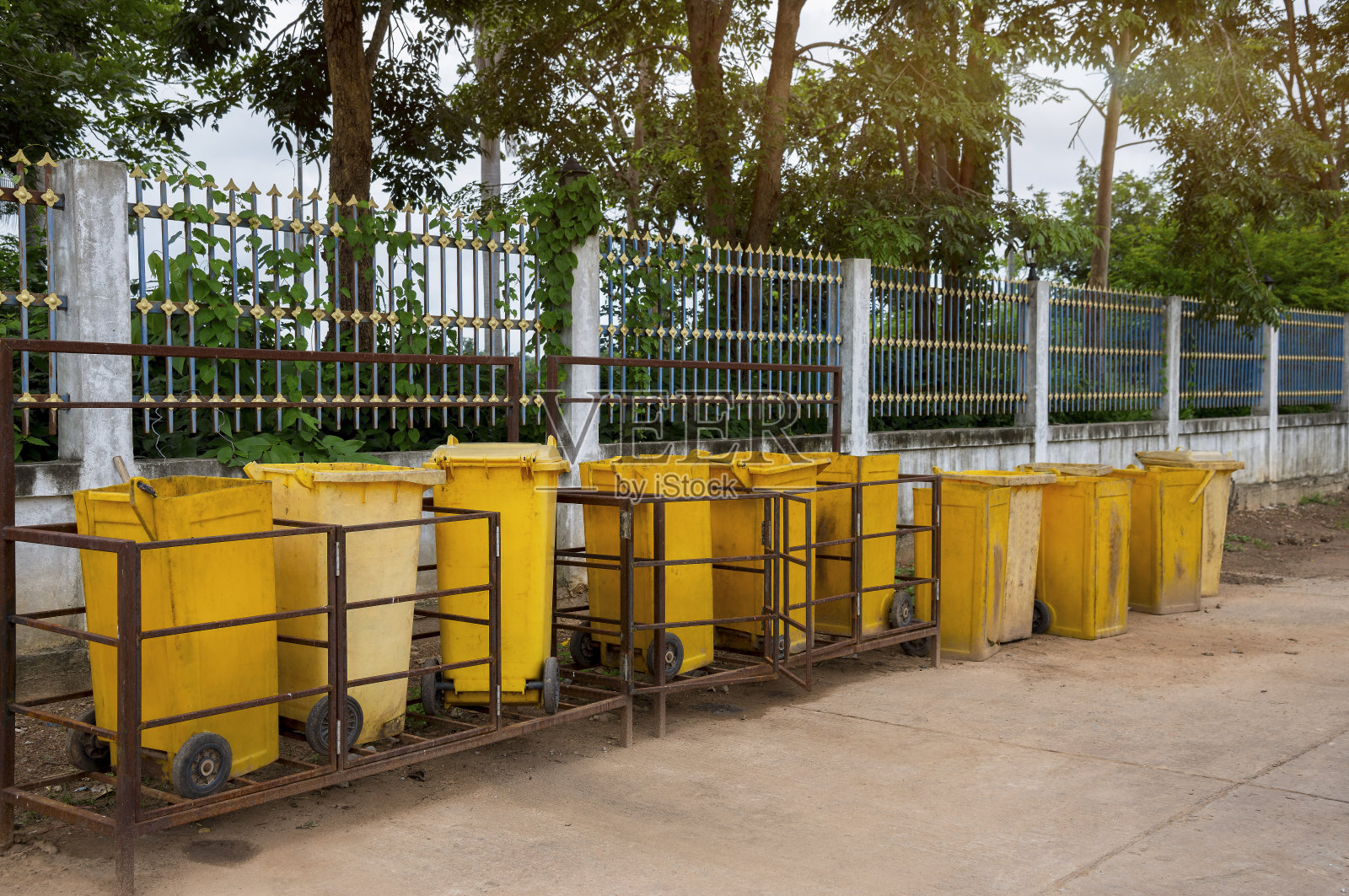 黄色的垃圾桶放在路边。照片摄影图片