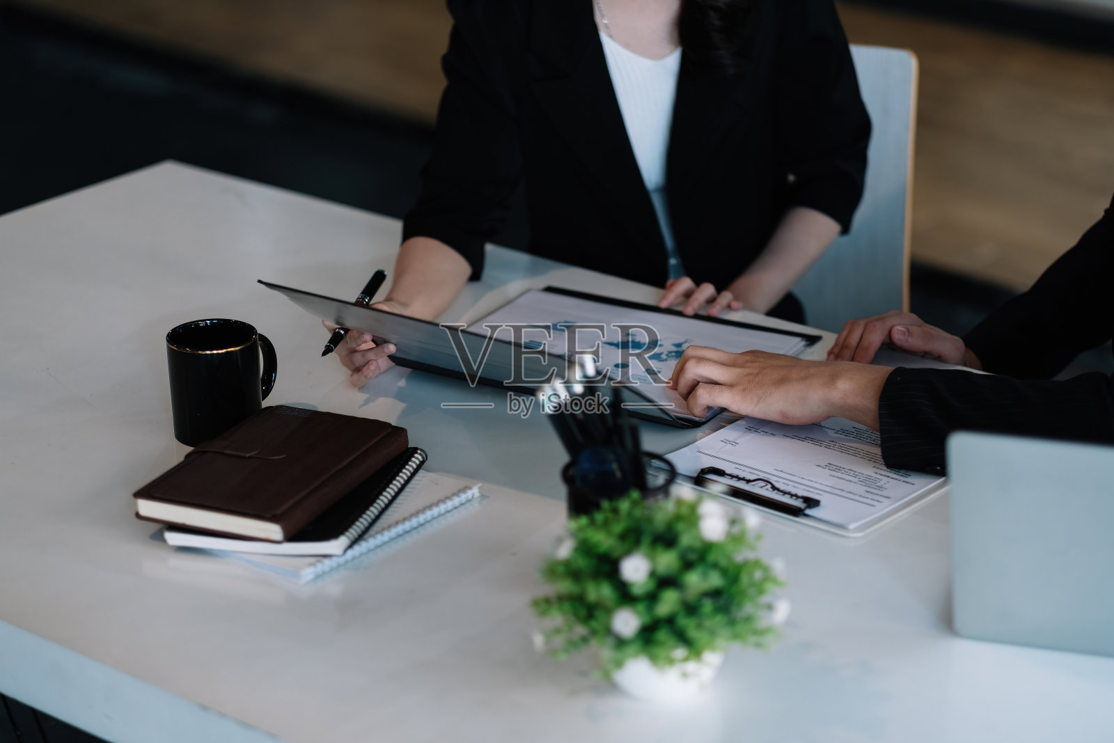 年轻的商业人士在办公室工作时使用电脑分析数据。会议讨论的概念照片摄影图片