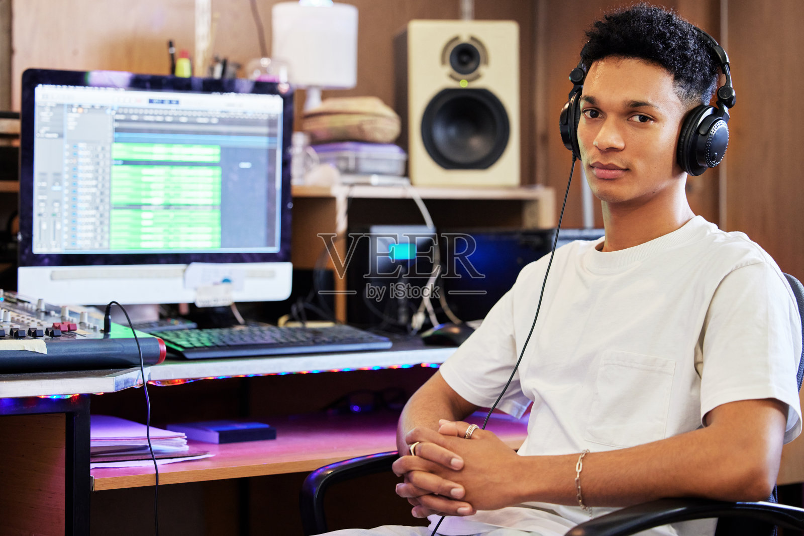 剪裁的肖像英俊的年轻男性音乐制作人在他的家庭办公室工作照片摄影图片