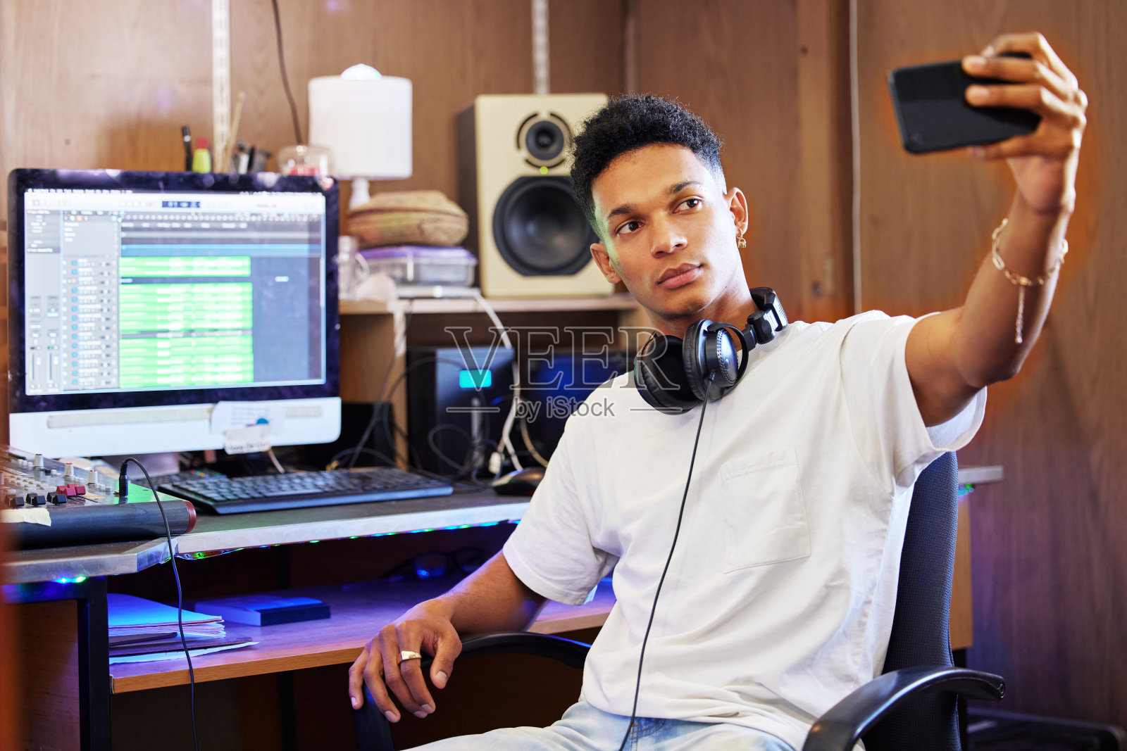 剪裁的照片，一个英俊的年轻男性音乐制作人在他的家庭办公室工作时自拍照片摄影图片