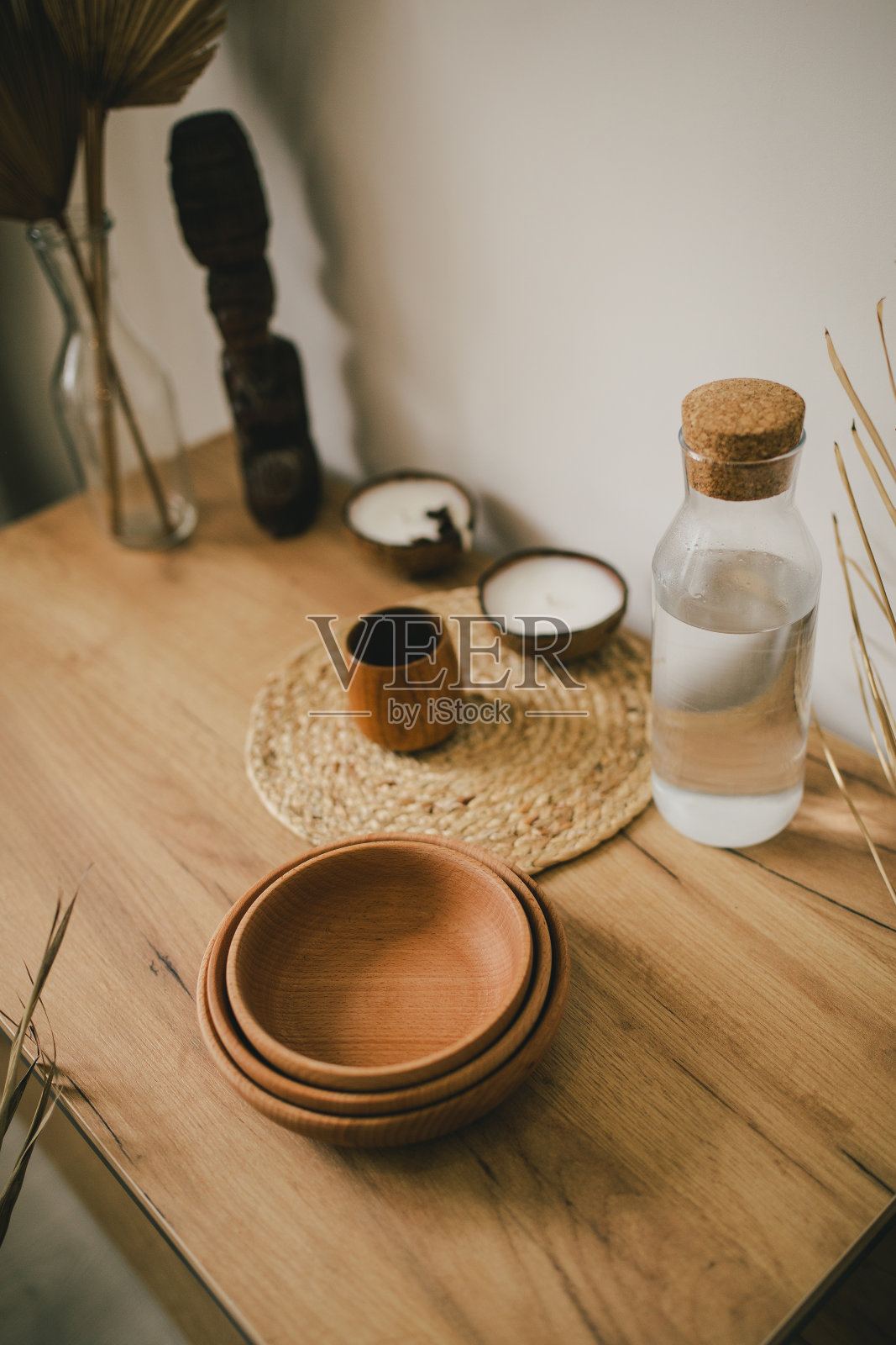 室内采用波西米亚风格，木制盘子，木桌上放着有机蜡烛。照片摄影图片