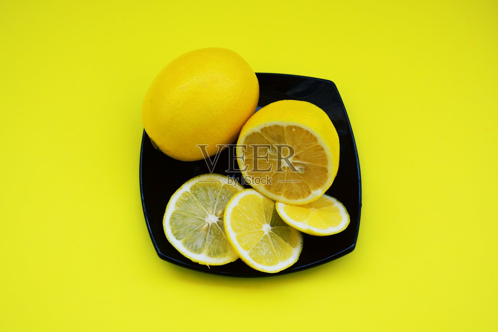 黑色盘子上的柠檬照片摄影图片