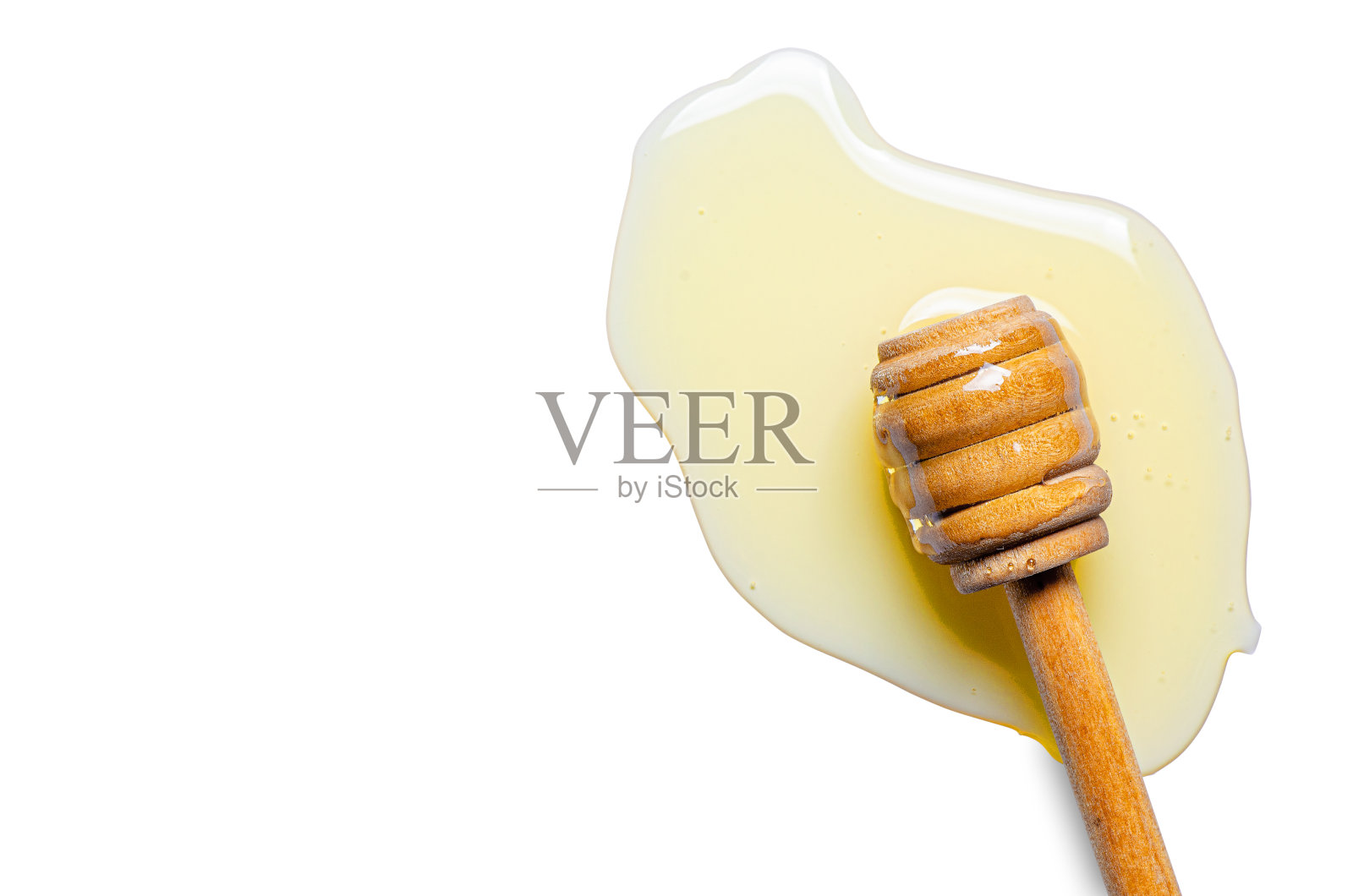 用木勺洒出新鲜的蜂蜜。白色背景。本空间照片摄影图片