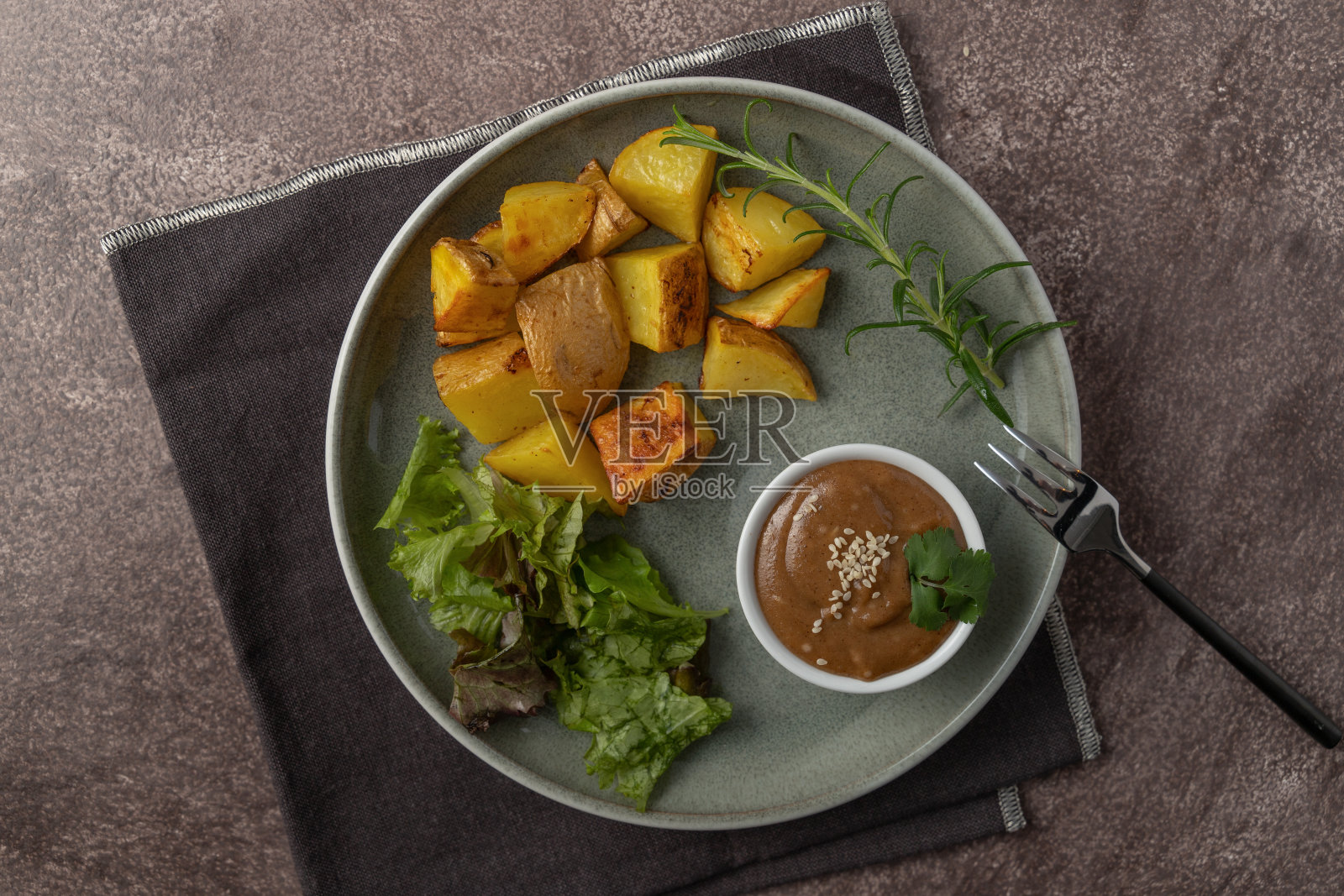 盘子里有沙拉，芝麻酱，土豆和迷迭香照片摄影图片