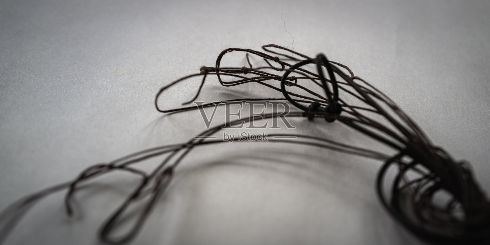 在白色背景上从右向左弯曲的棕色弦照片摄影图片