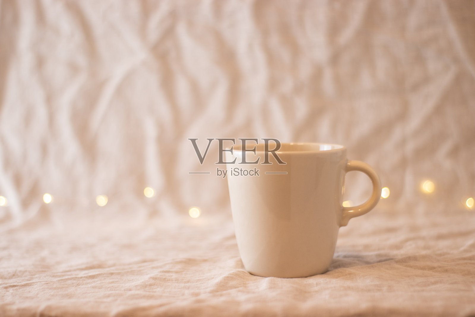米色空咖啡杯，在织物上，孤立的背景照片摄影图片