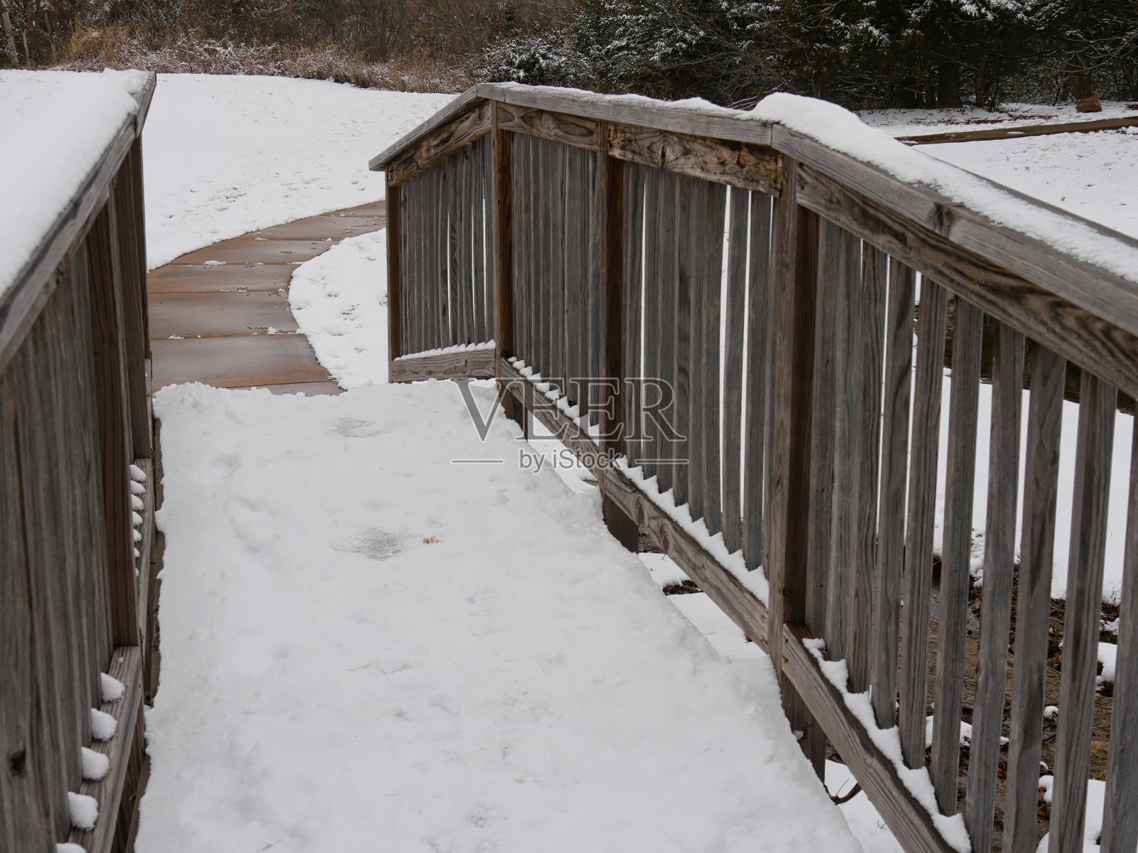 湖边一座被雪覆盖的木桥的特写镜头照片摄影图片