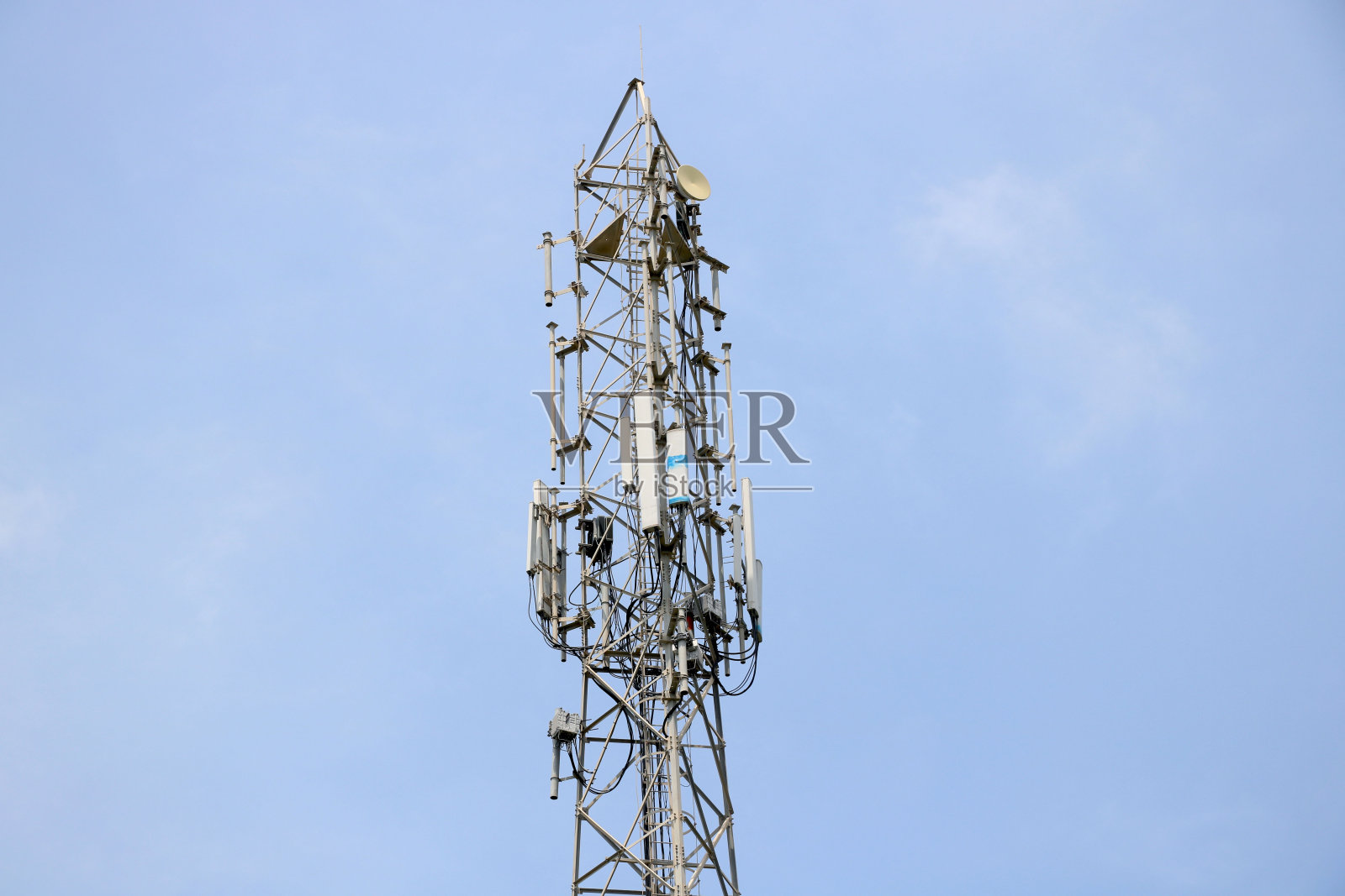 湛蓝的天空中耸立着装有电视天线和卫星天线的电信塔照片摄影图片