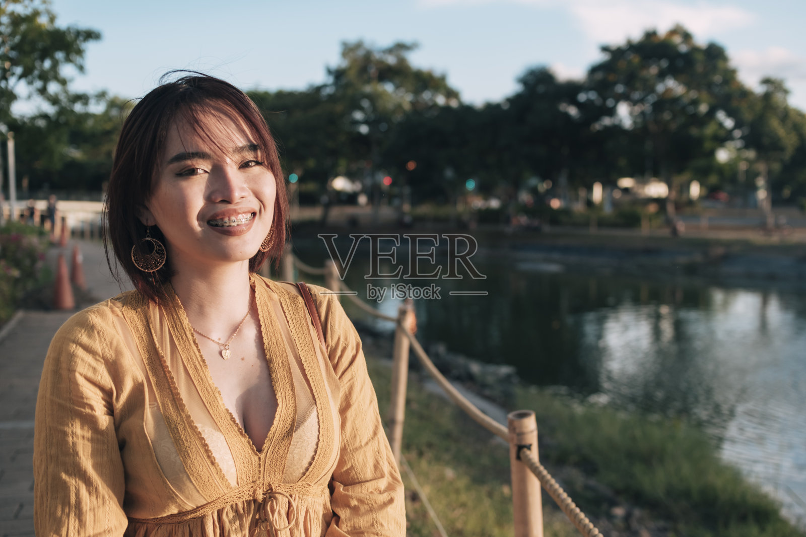 一个优雅的菲律宾女人在一个有大喷泉的公园，休闲和非正式的穿着。享受户外的周末。照片摄影图片