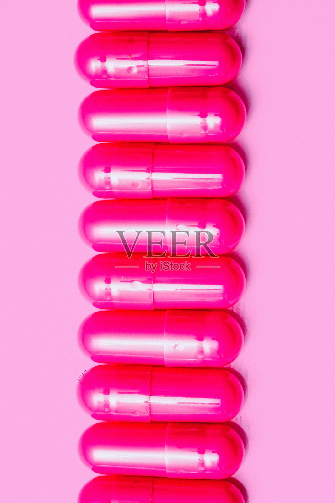 通用的粉红色明胶药丸在粉红色的背景照片摄影图片