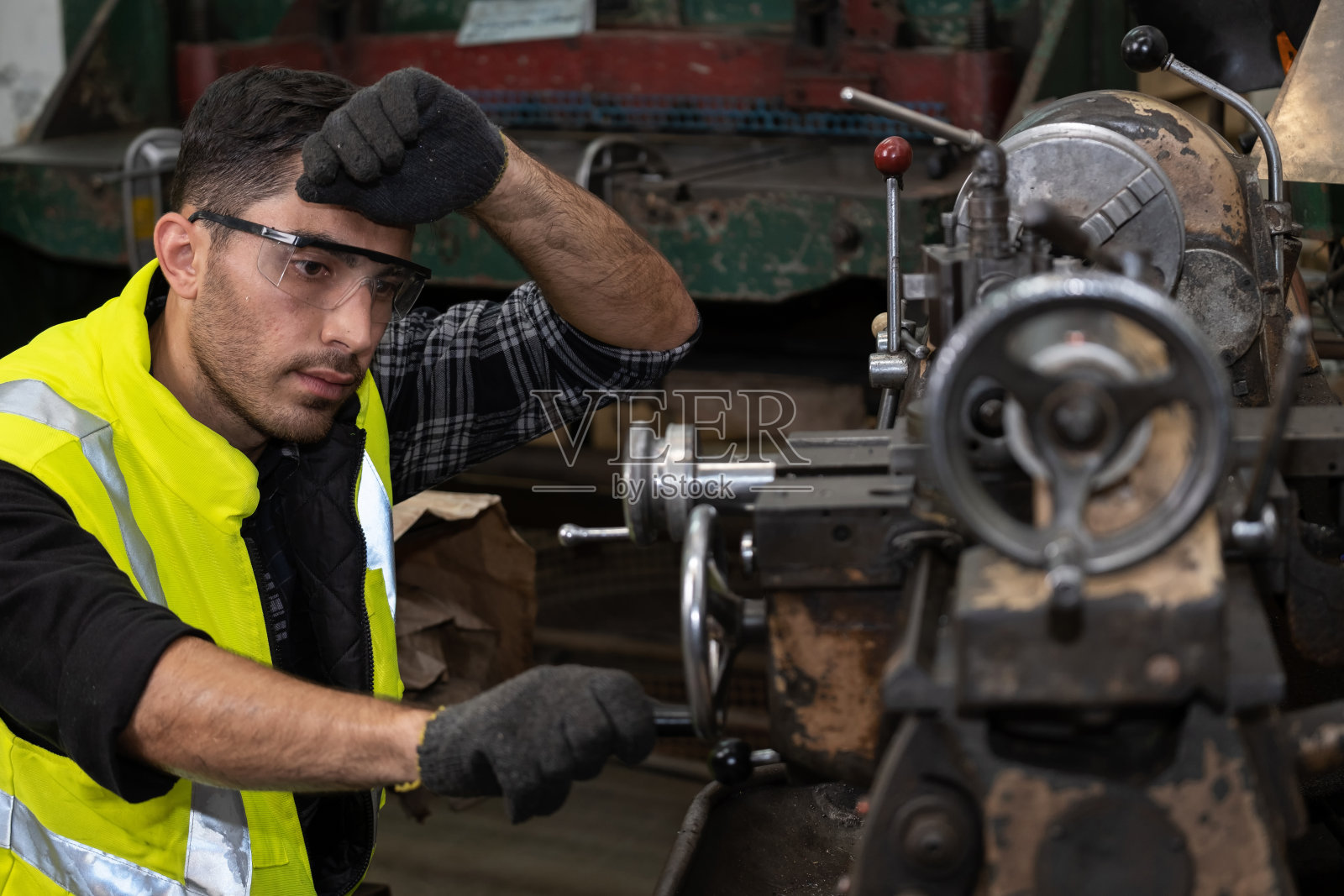 在CNC金属工厂进行机械维护或维修工作。在工作累了。生产前设备检查。工业和制造业照片摄影图片